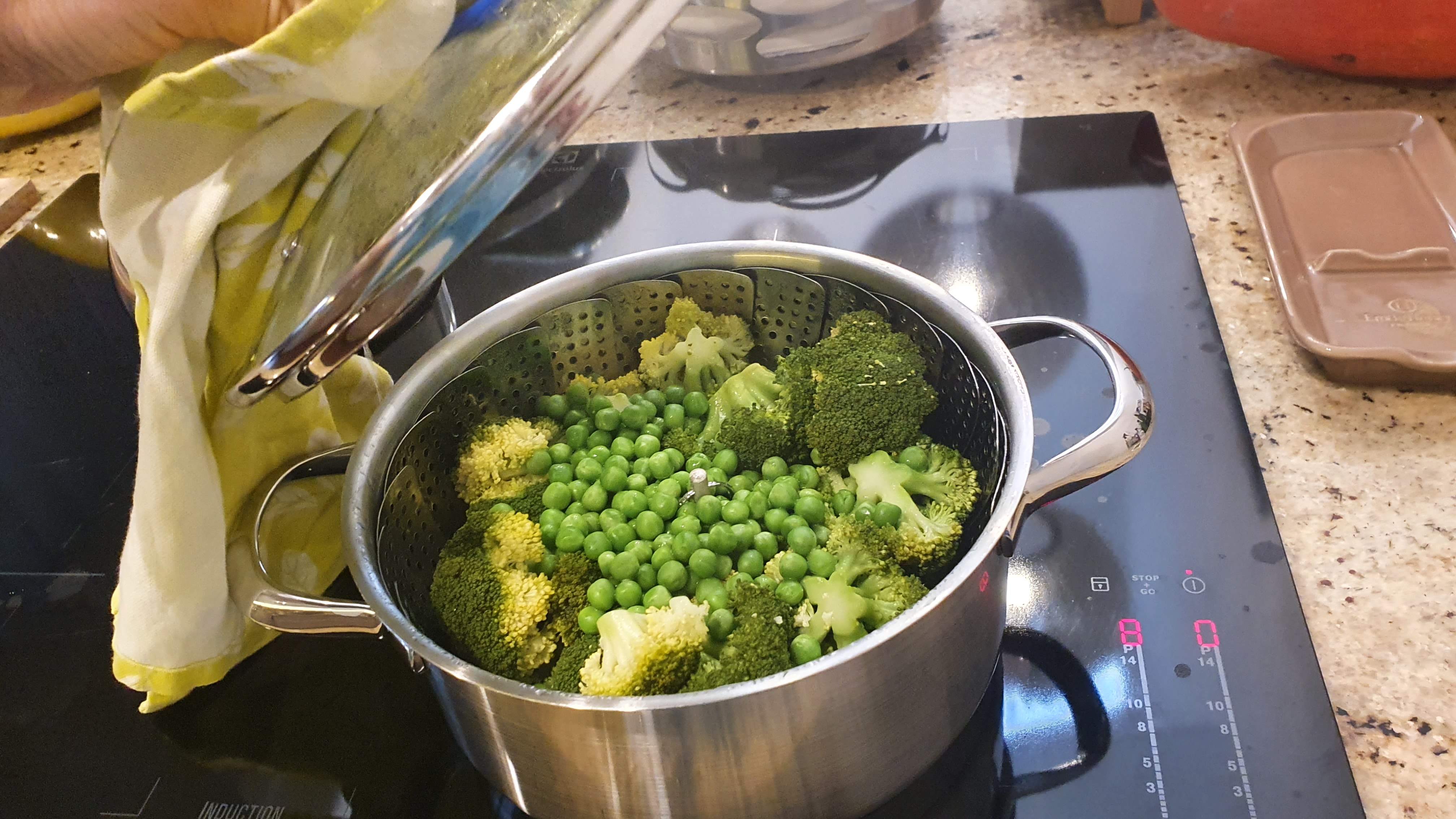 Brokolicu umyjeme, rozdelíme na menšie časti a naparujeme približne 10 minút. Na posledné 3 minúty k nej prihodíme 2 hrste mrazeného hrachu.