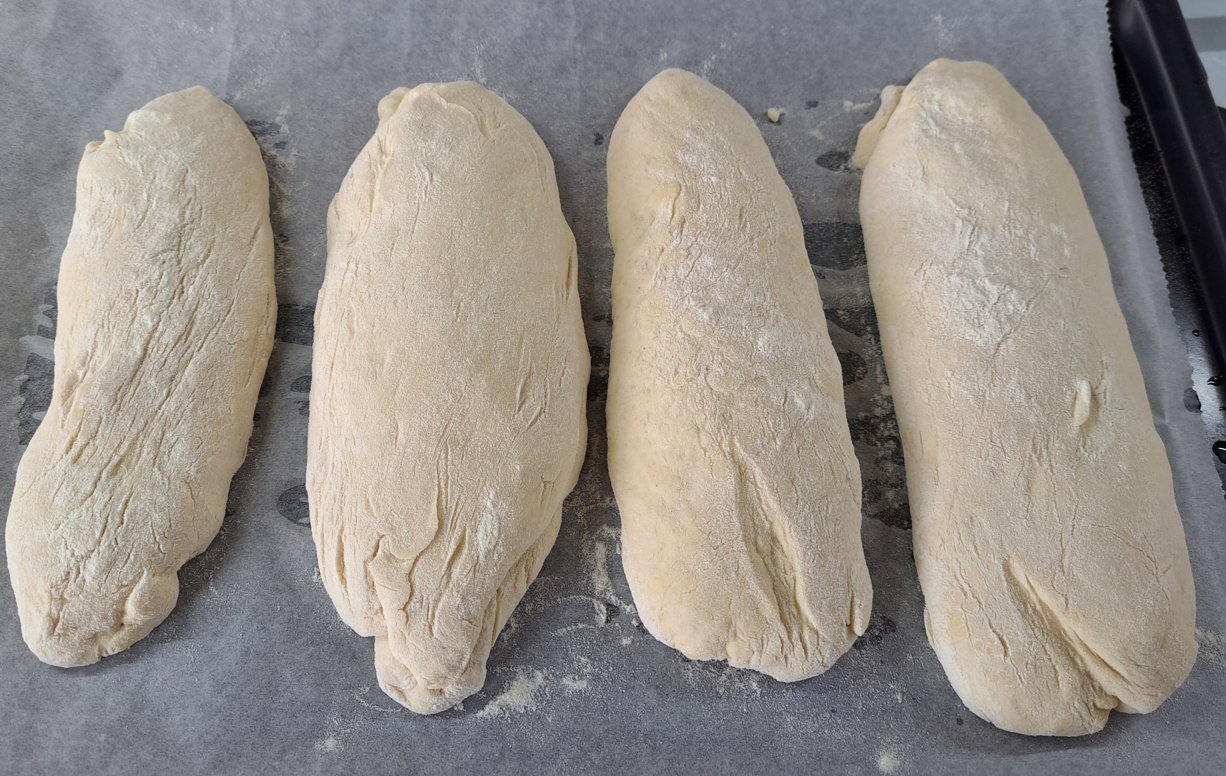 Ciabatty preložíme na plech vystlaný papierom na pečenie a necháme ešte 15 minút odpočívať prikryté kuchynskou utierkou