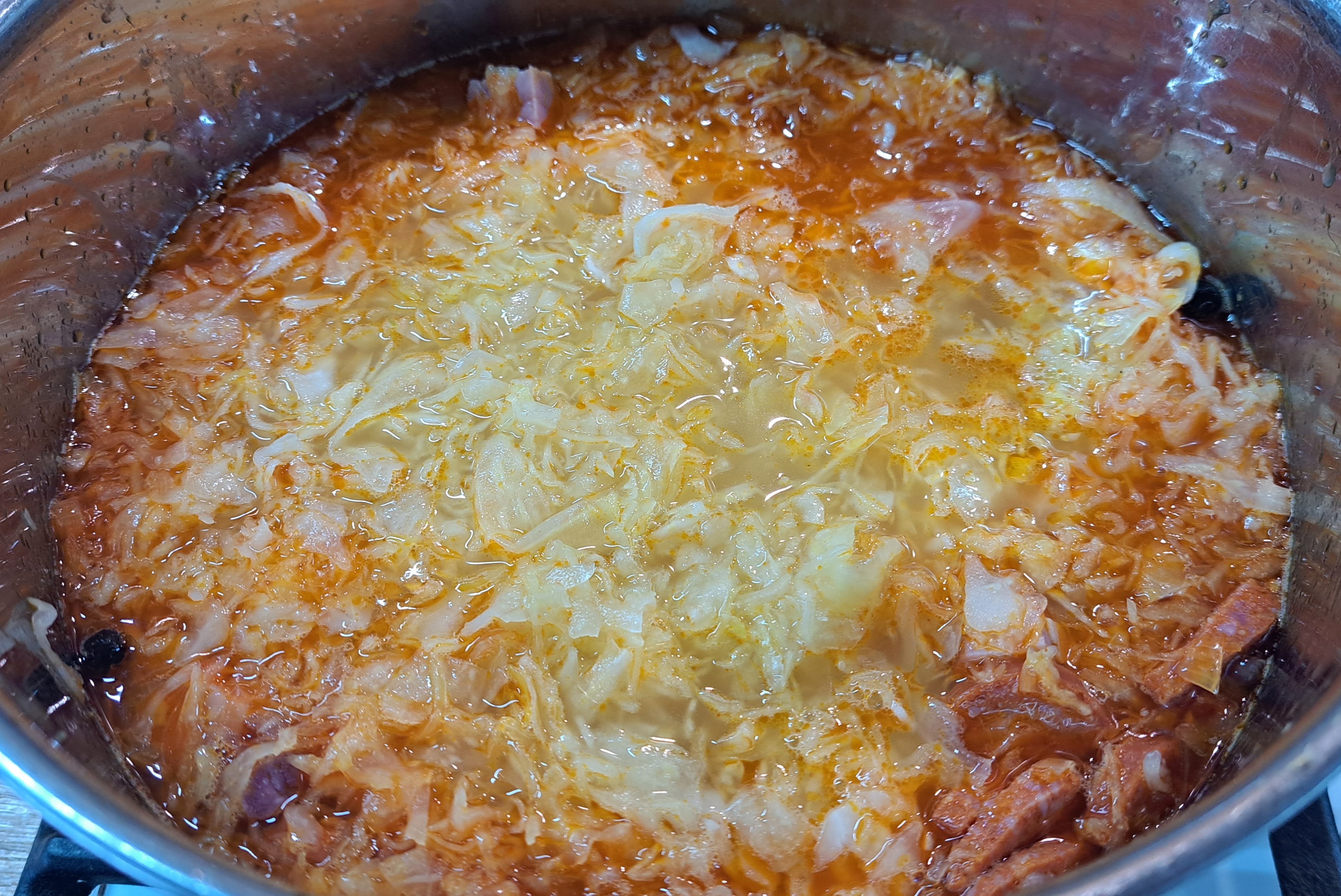 Nakrájanú kapustu spolu s kapustovou vodou pridáme do hrnca a celý obsah premiešame