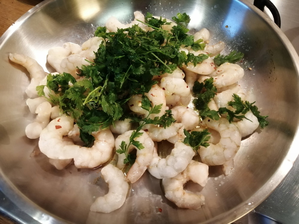 Na panvicu nalejeme trochu olivového oleja a pridáme krevety, morskú soľ, chilli papričku alebo chilli korenie a čerstvú petržlenovú vňať. 