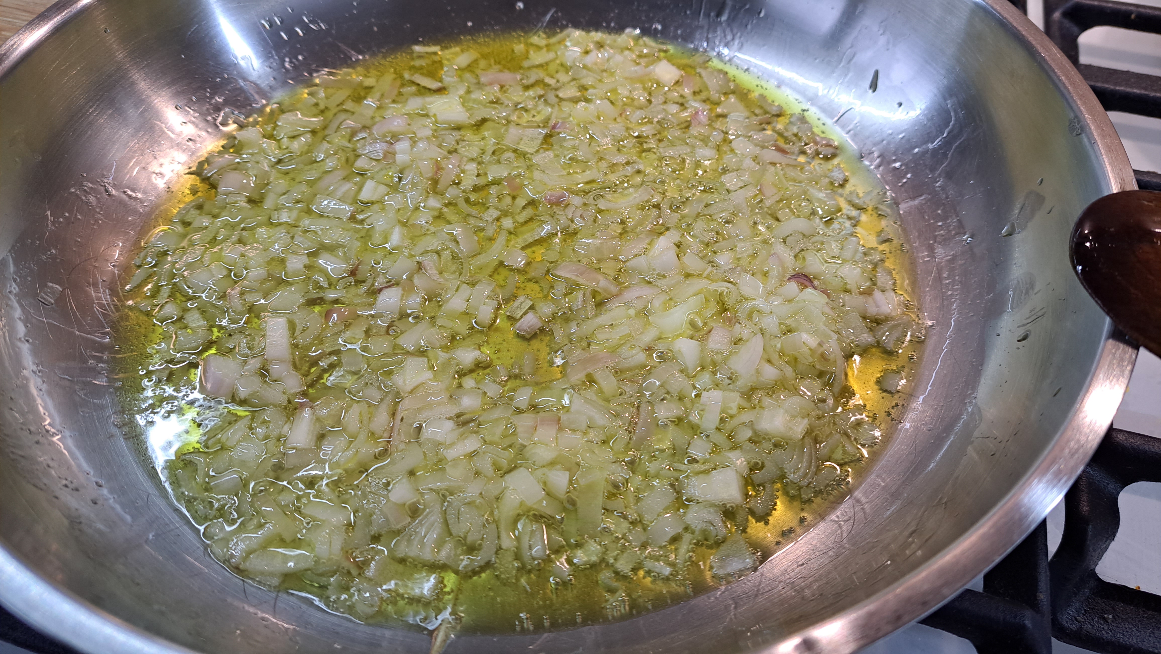 Na panvicu pridáme olivový olej s kúskom masla a osmažíme na ňom najemno nakrájané šalotky