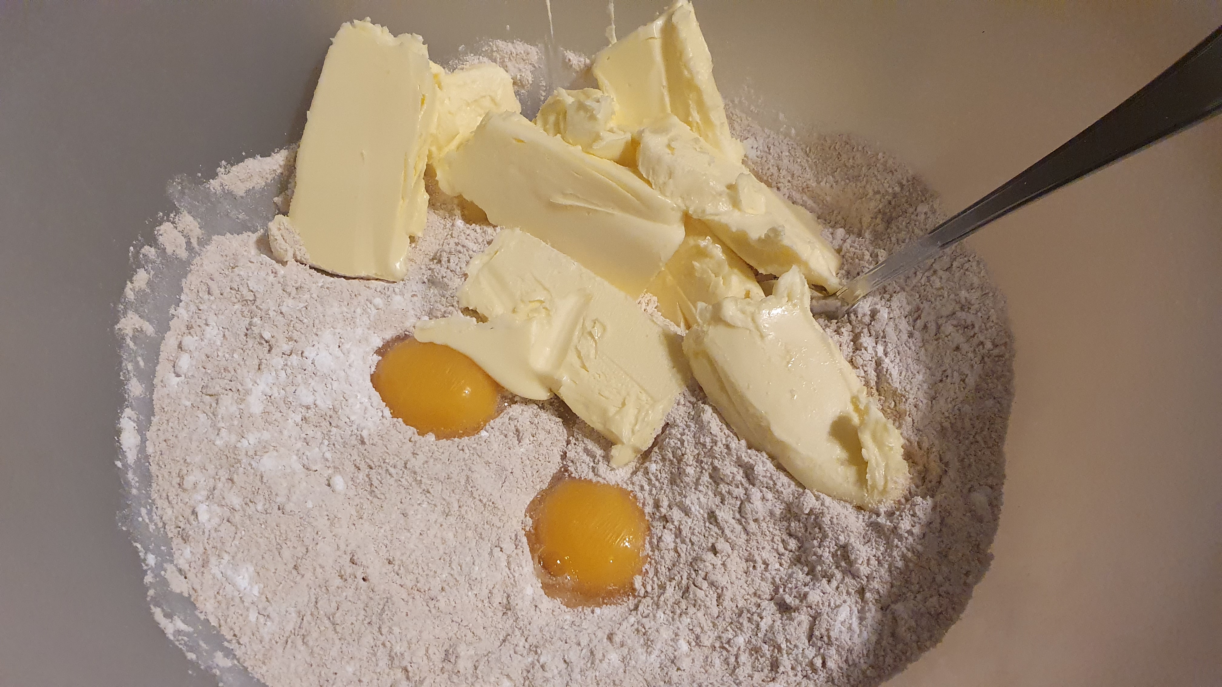 Maslo si vyberieme z chladničky o 3 hodiny skôr, aby zmäklo a zo všetkých ingrediencií vymiešame cesto. Zo začiatku sa nenecháme odradiť tým, že sa rozpadáva, časom sa spojí.