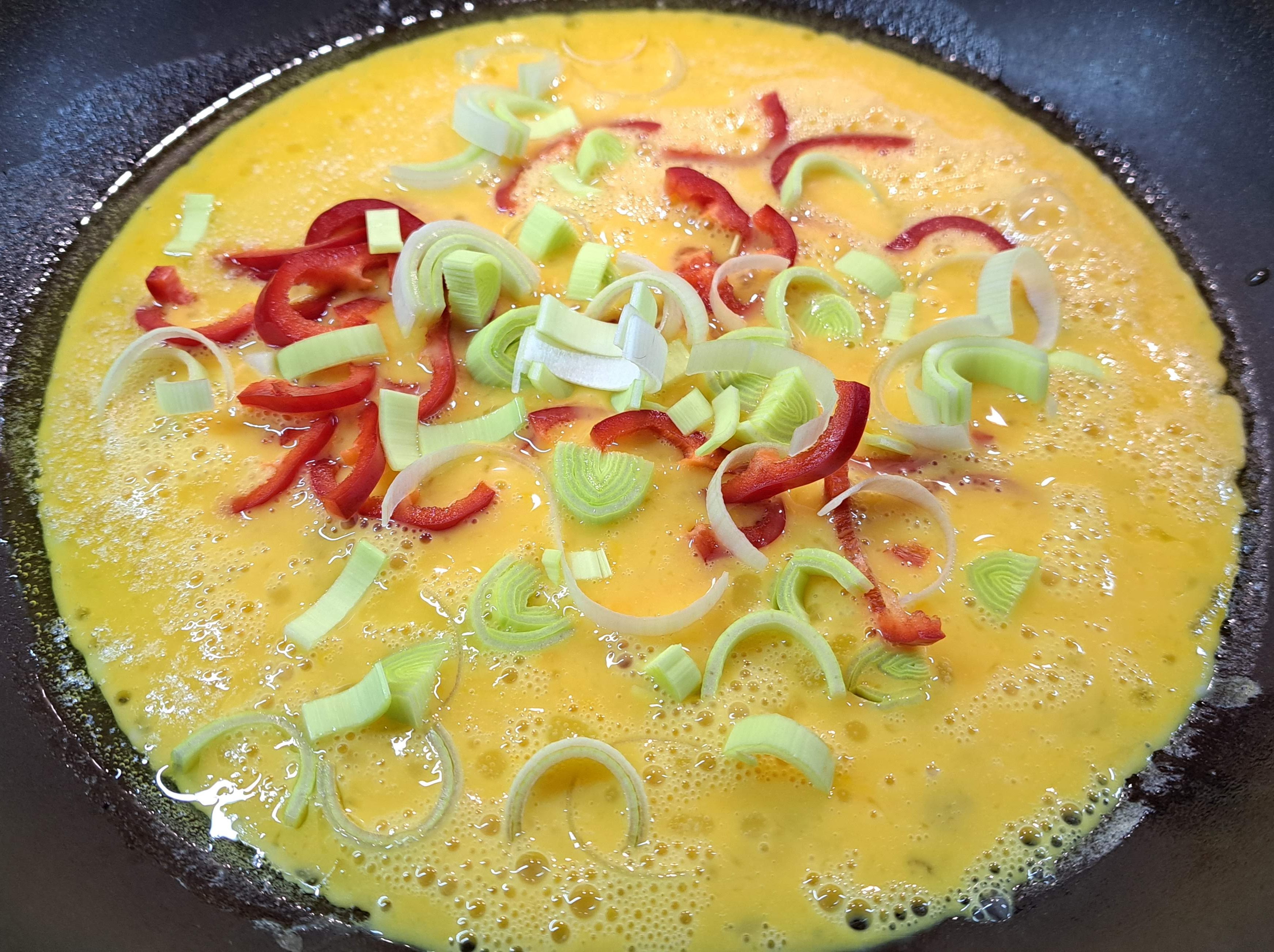 Na panvicu do vajec pridáme nakrájanú papriku a pór