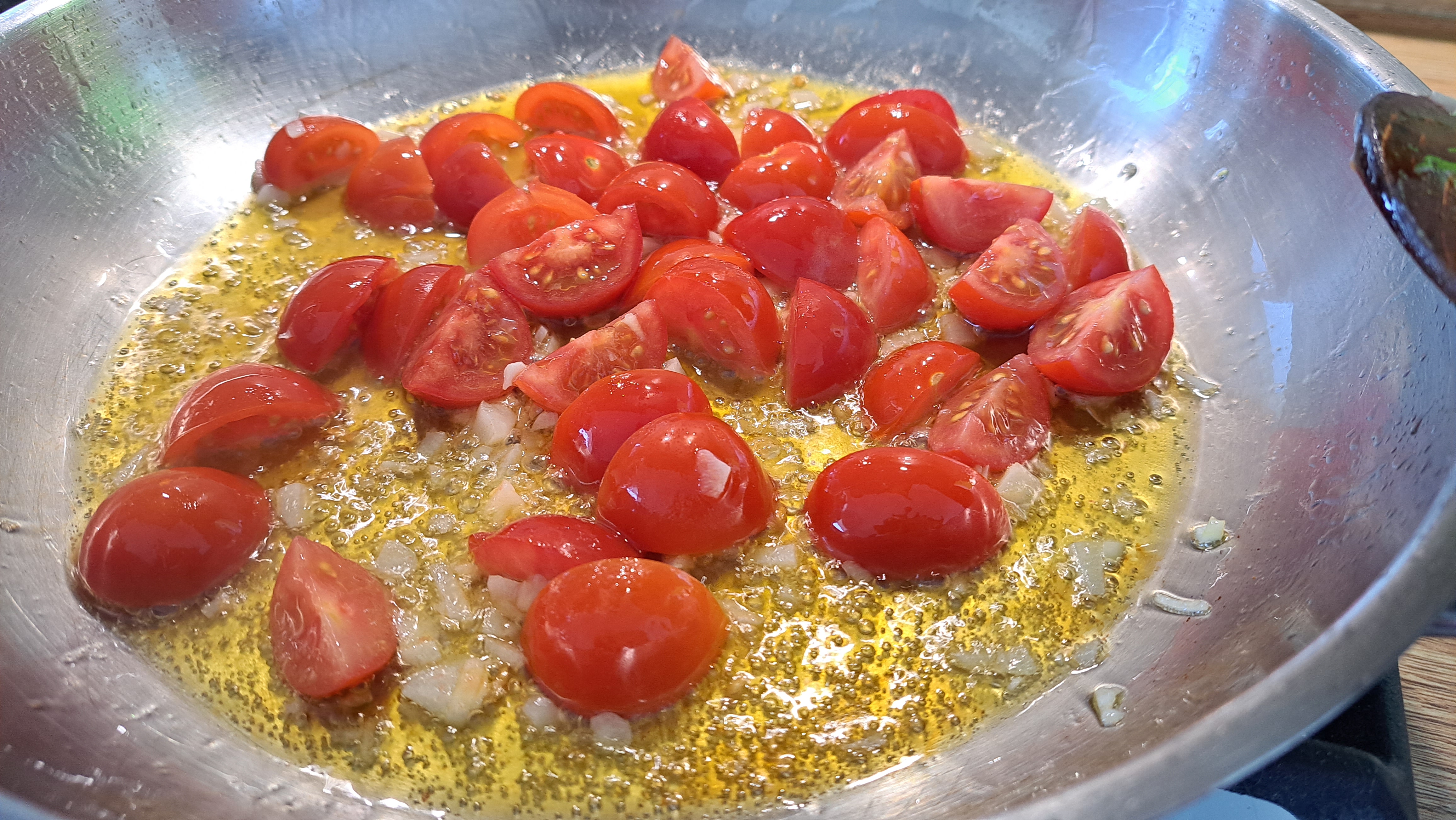 Najprv pridáme paradajky a premiešame ich s olejom, do zmesi neskôr pridáme cesnak, aby nám v oleji nezhnedol a nezhorkol.