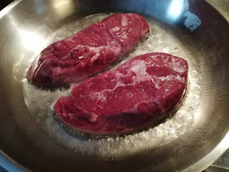 Steaky potrieme ich olivovým olejom a vložíme do rozpálenej panvice. Teplotu treba čo najvyššiu, aby sa mäso zatiahlo a ostalo vo vnútri šťavnaté.