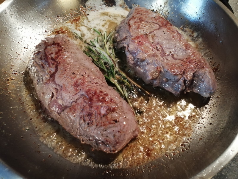 Keď sa maslo rozpustí, polievame steak zmesou oleja a masla s bylinkami.