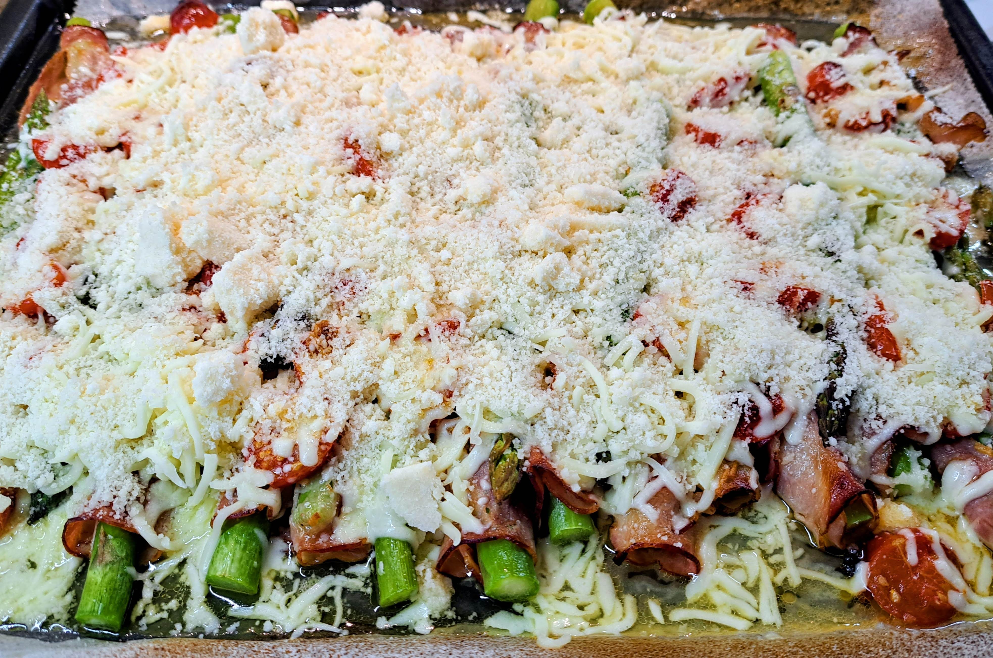 Po upečení vyberieme plech z rúry a posypeme ho nastrúhanou Mozzarellou a nastrúhaným Grana Padano