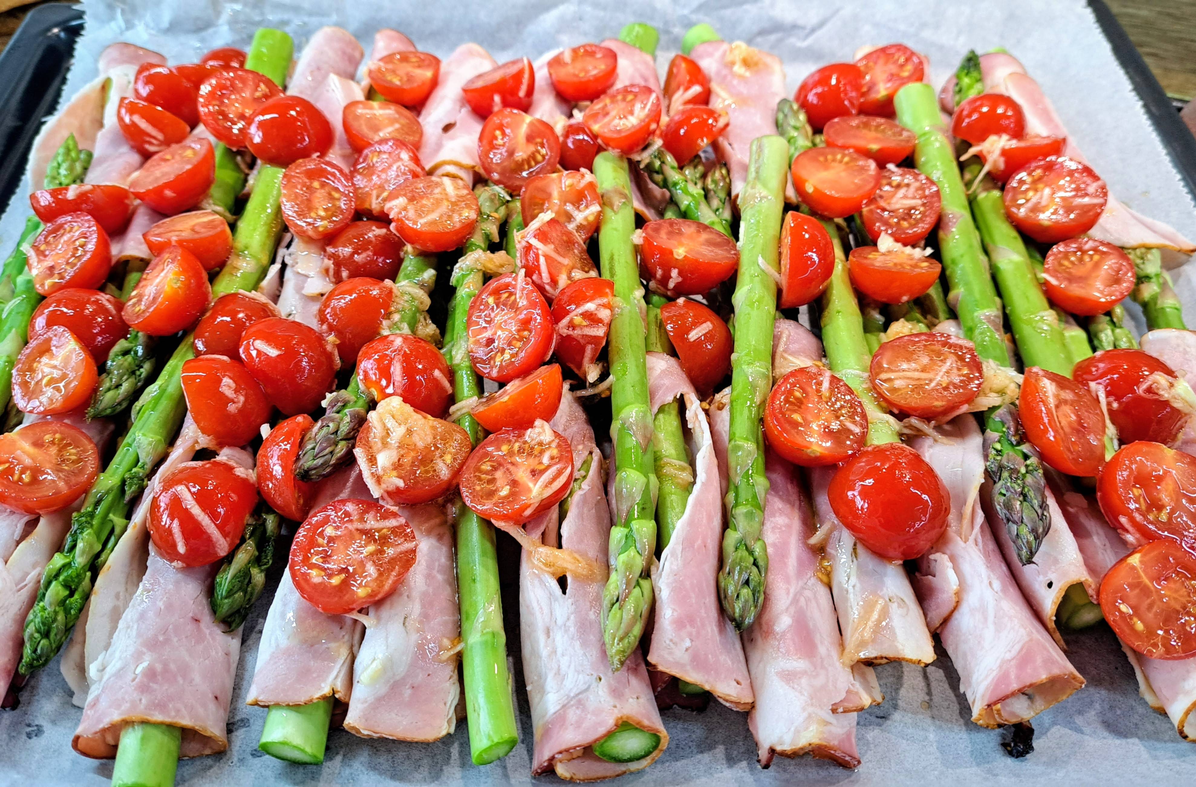 Mix cherry paradajok s cesnakom, korením a olivovým olejom rozložíme pomedzi pripravenú špargľu na plechu na pečenie