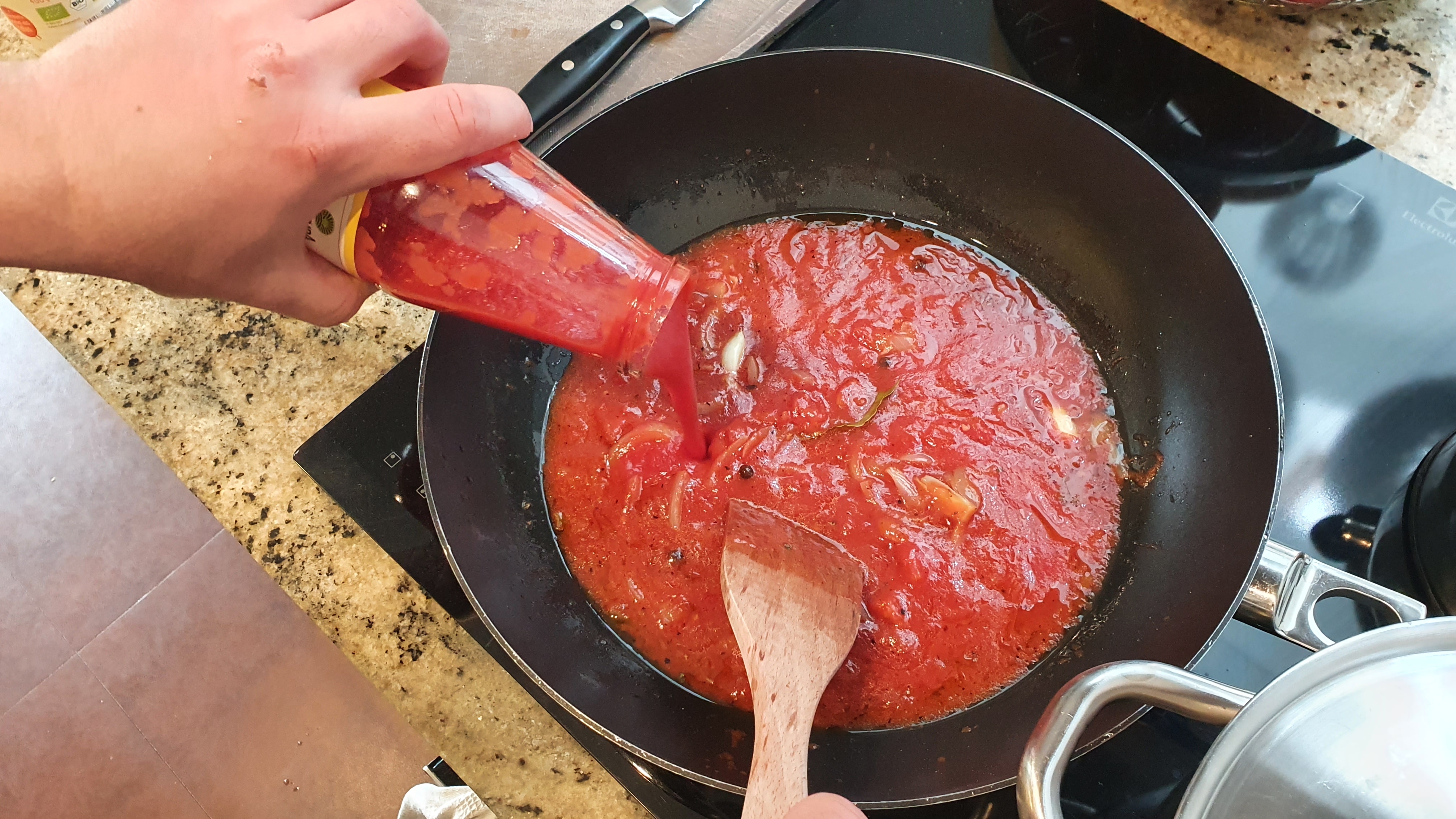 Pridáme dva celé strúčiky cesnaku, konzervu nasekaných paradajok a paradajkový pretlak. Ochutíme sušenou bazalkou, soľou, mletým korením a 20 minút necháme vrieť.