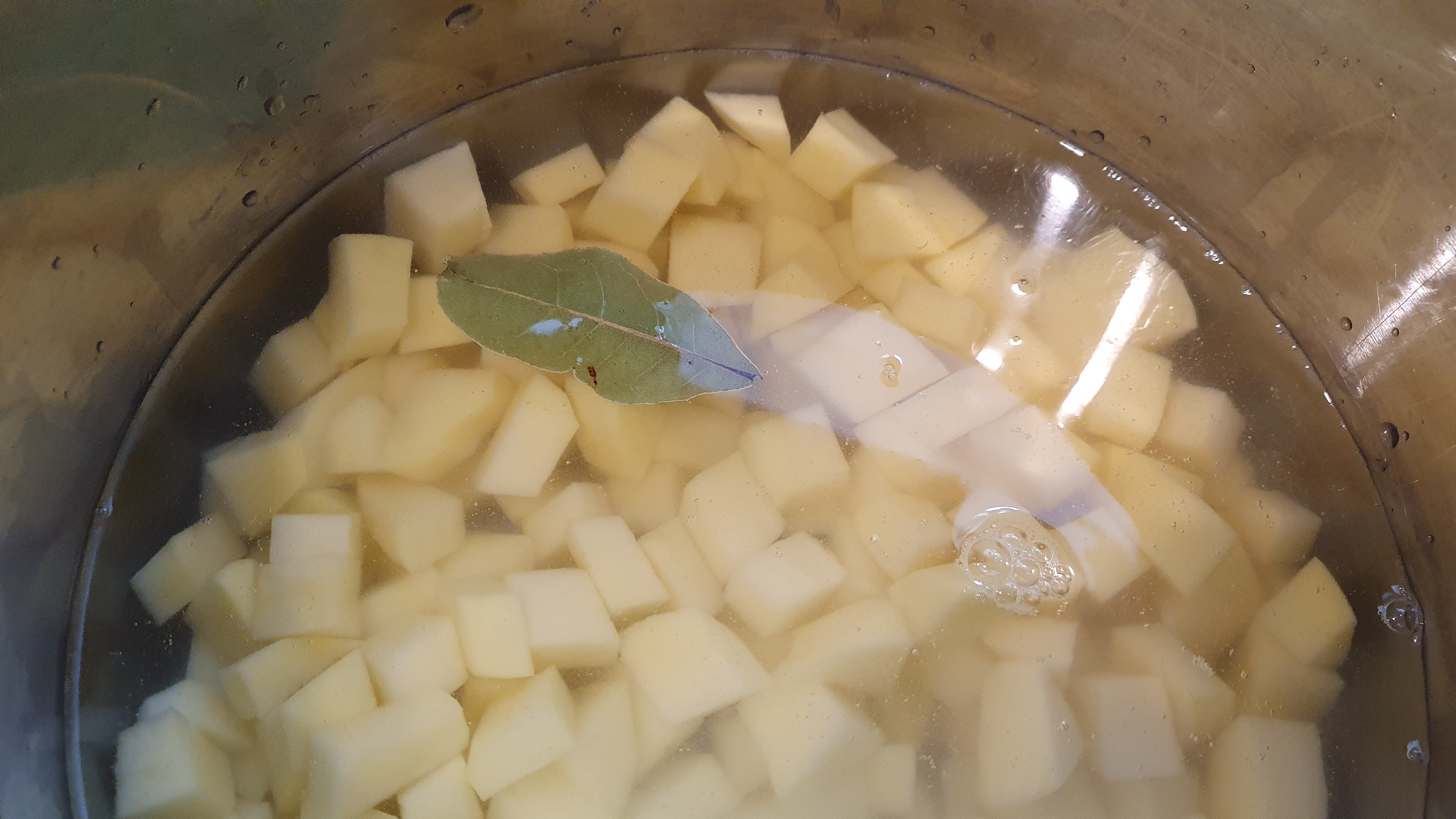 Štyri stredne veľké zemiaky ošúpeme a nakrájame na malé kocky. Vložíme do hrnca spolu s bobkovým listom a 3 guľôčkami čierneho korenia. Osolíme a povaríme asi 15 minút (záleží od druhu zemiakov).